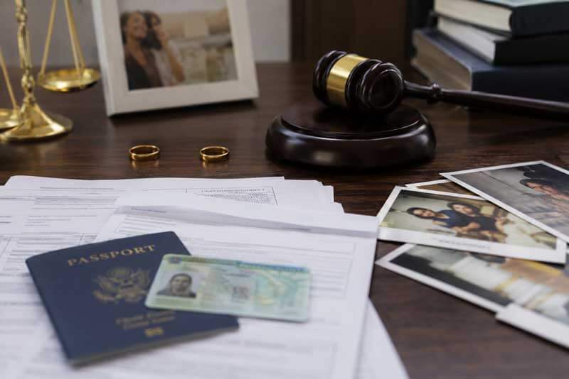 Immigration documents, a passport, and rings related to a divorce and residency case